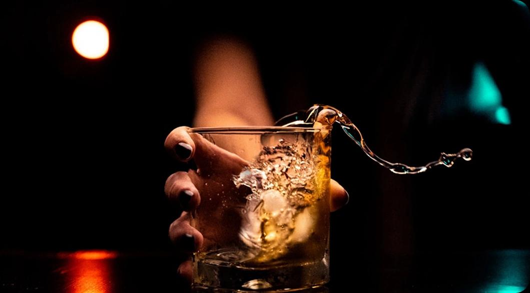 Spilling alcoholic drink — visual metaphor for choosing sobriety through alcohol addiction treatment in Newport Beach.
