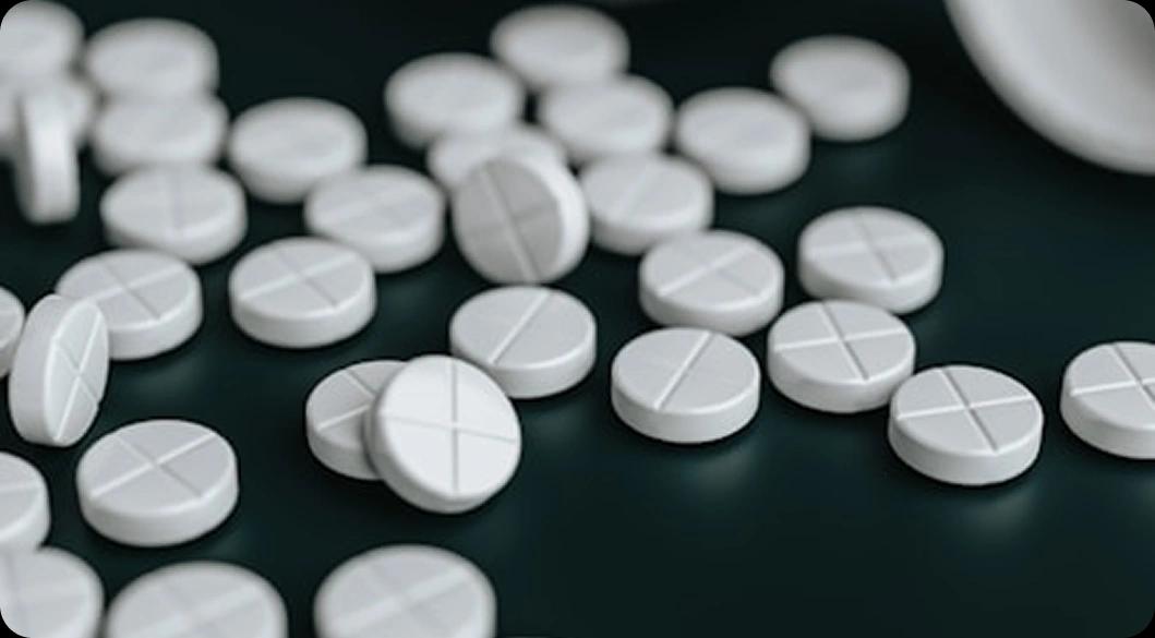 Scattered white pills symbolizing the opioid crisis — compassionate fentanyl and opioid rehab treatment available in Newport Beach.