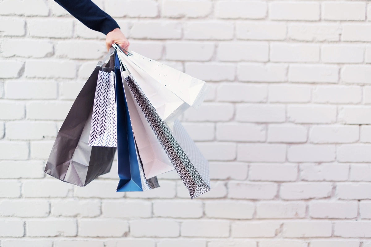 Shopping Addiction: Man holding several shopping bags