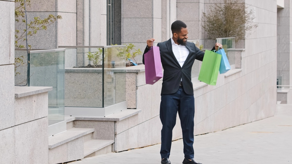 Shopping Addiction: Man holding multiple shopping bags