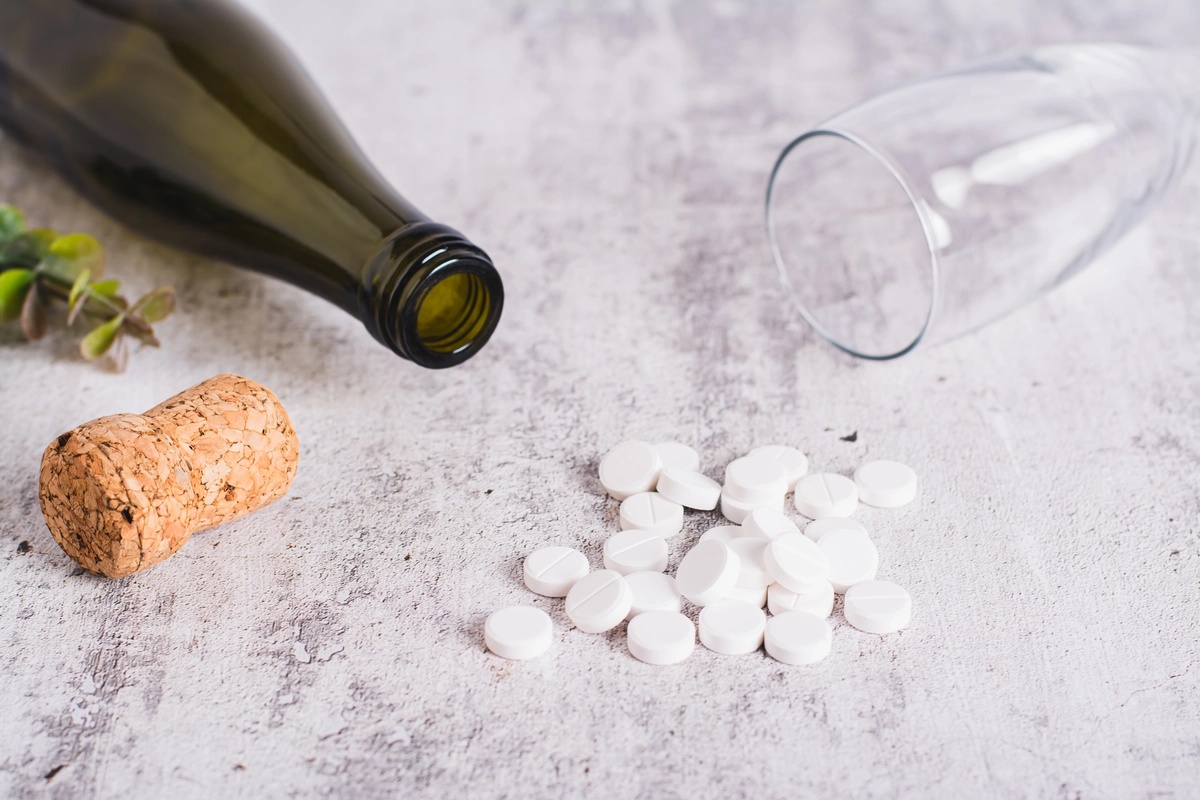Xanax Addiction: Pills in a pile next to a wine bottle and glass