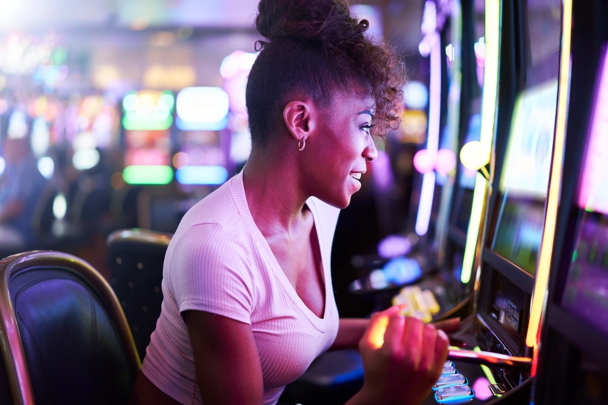 Gambling Addiction: Woman happily playing slot machine