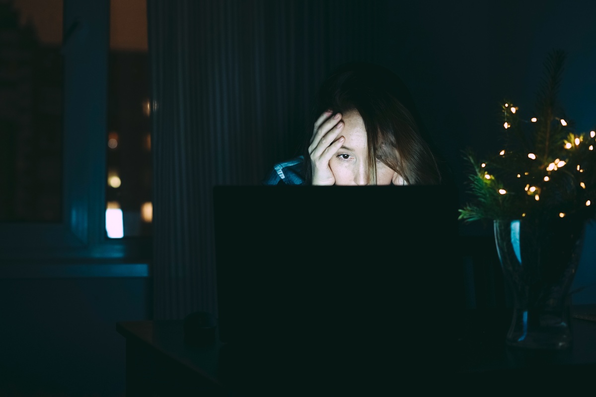 Internet Addiction: Woman in the dark staring at her computer