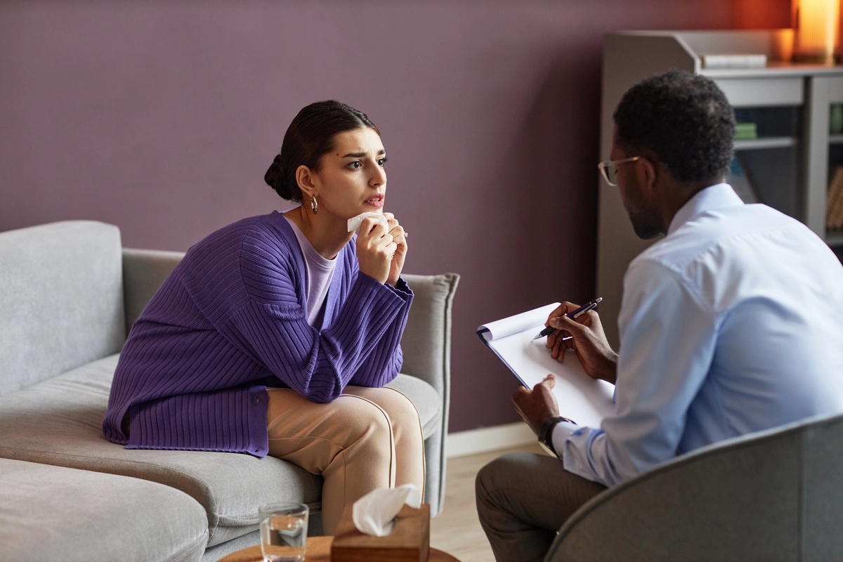 Individual Therapy: Woman in purple sweater listening intensely to therapist