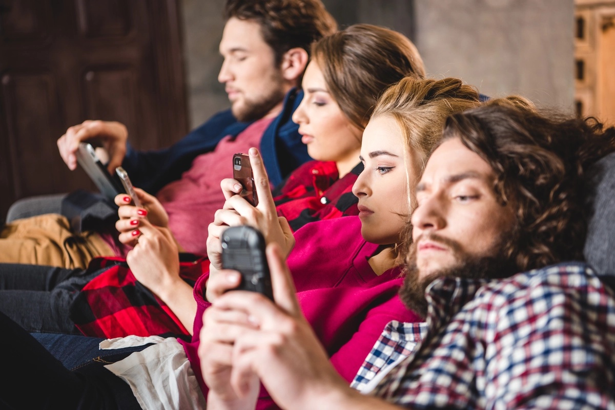 Phone Addiction: Friends staring at their phones instead of being social