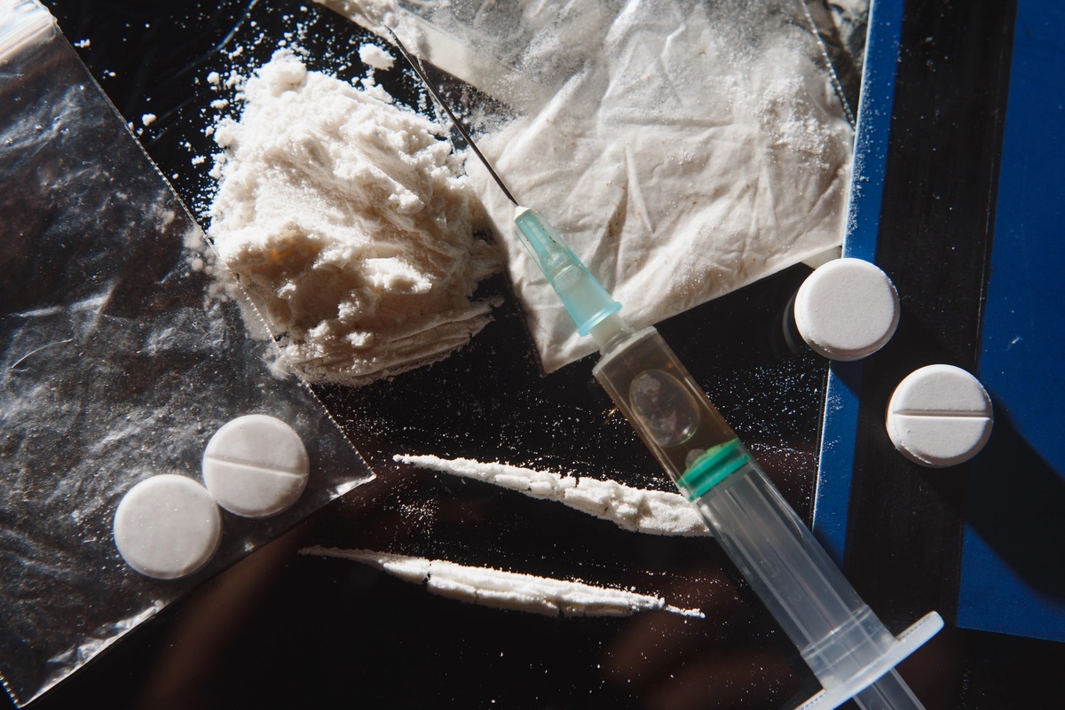 Stimulant Addiction: Syringe, pills, and powder on a table