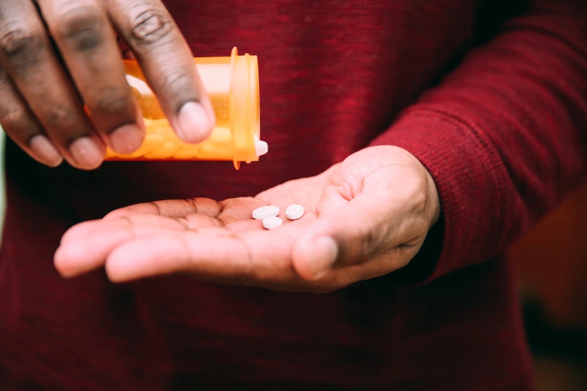 Fentanyl Addiction: Pills being poured out of a bottle on a hand