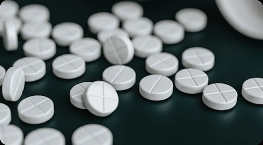 Scattered white pills symbolizing the opioid crisis — compassionate fentanyl and opioid rehab treatment available in San Clemente.