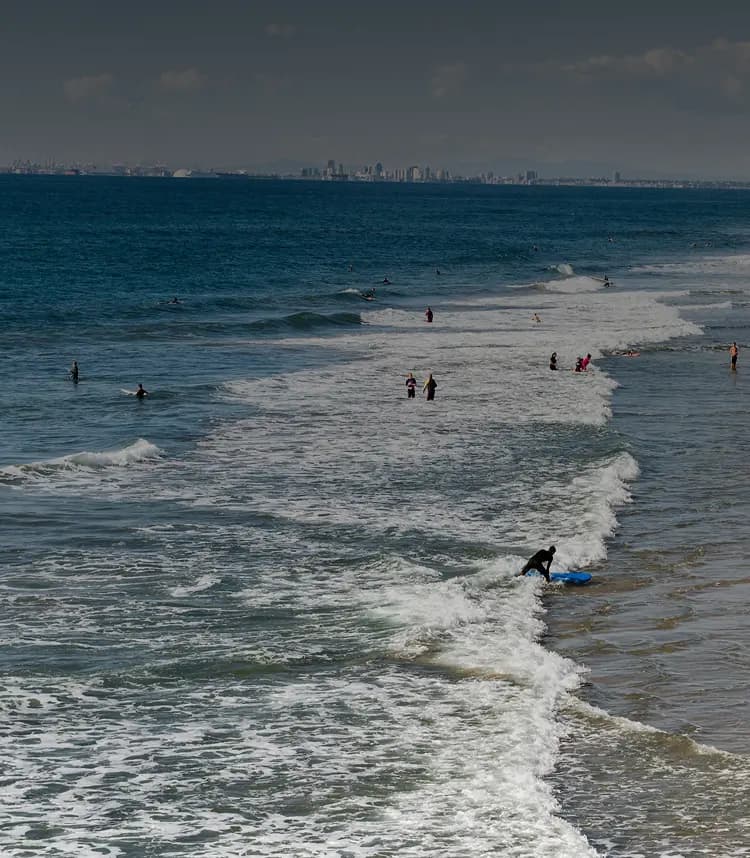 Drug Rehab in Seal Beach Drug rehab in Seal Beach - Surfers and beachgoers enjoying the waves in Seal Beach — a calm and inviting setting for addiction recovery and healing.