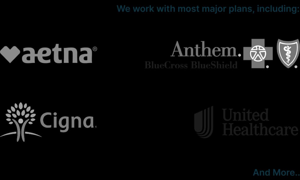 Bright orange county rehab therapy room with therapist looking at patients charts happily.